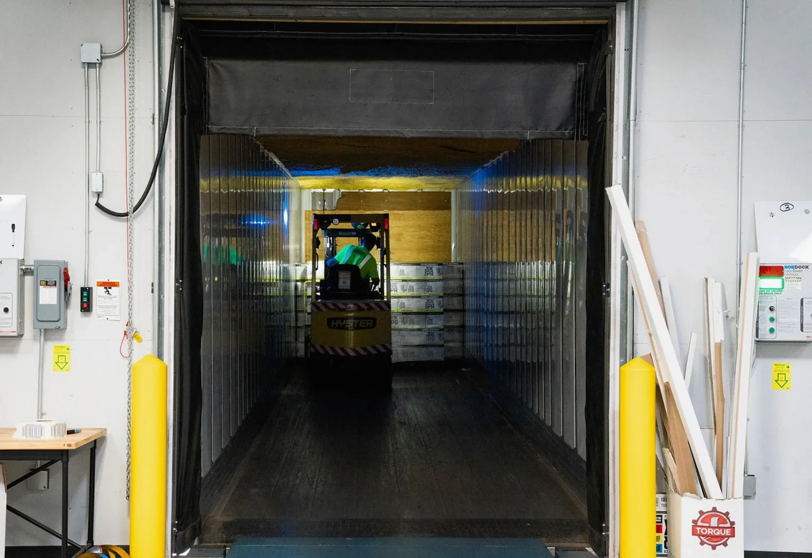 トラックの荷台の中をフォークリフトが走る、荷積みドックの様子